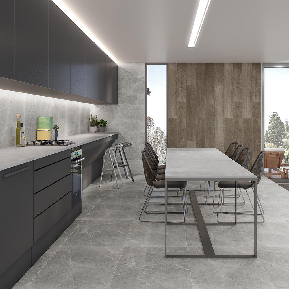 Modern kitchen with gray cabinets, marble countertops, and a dining area.