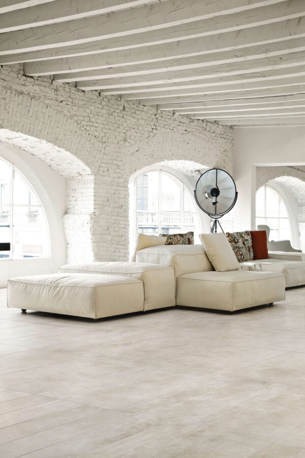 Modern living room with white walls, wooden floor, and a large sectional sofa.