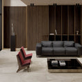 Modern living room with a black sofa, red chair, and glass coffee table.